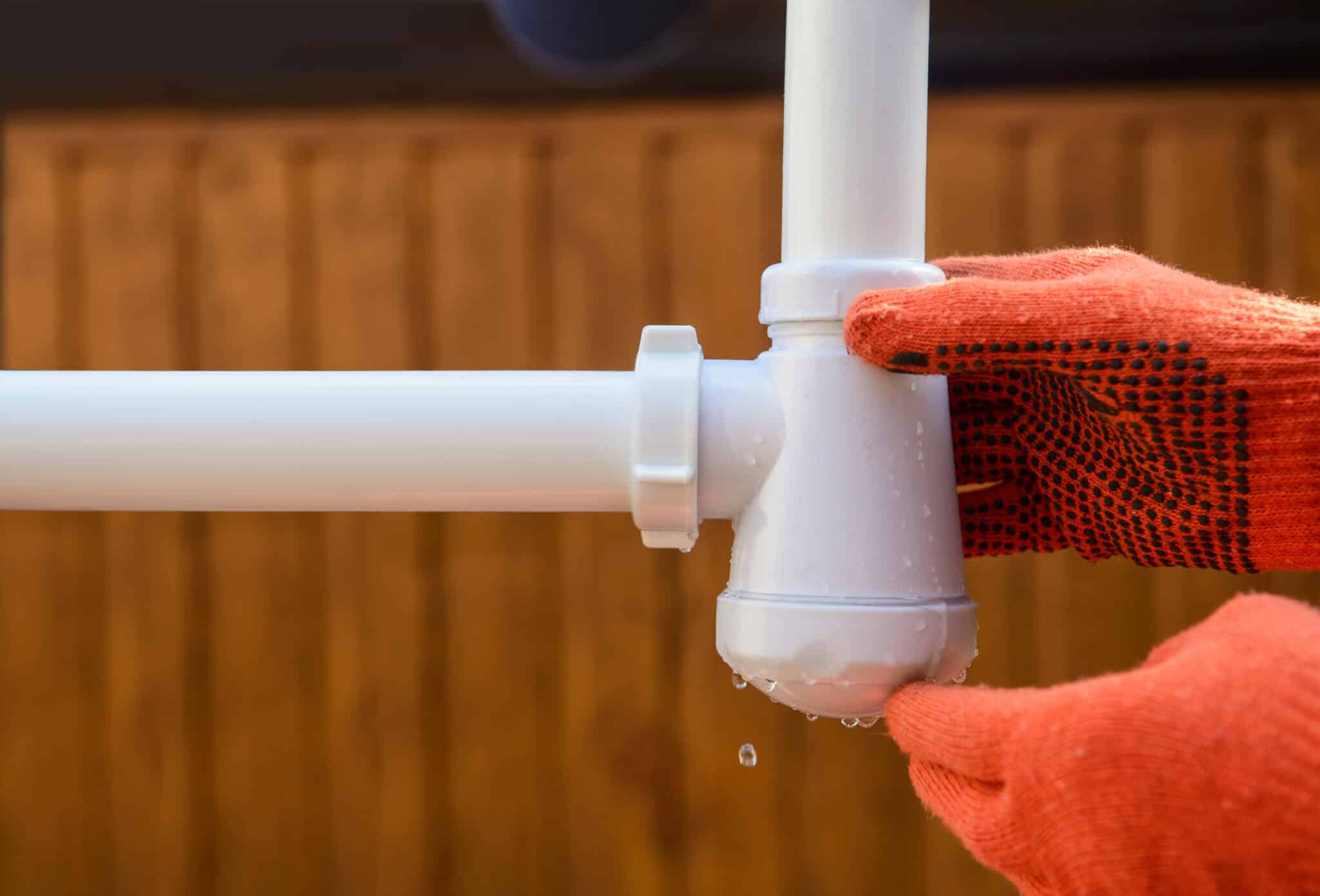 Close-up of a leaking pipe, highlighting the importance of expert plumbing maintenance.